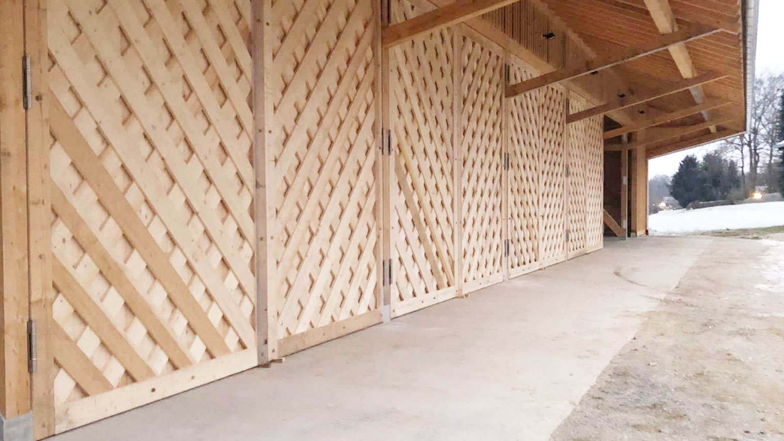 Detailaufnahme einer Holzfassade mit diagonalem Muster.