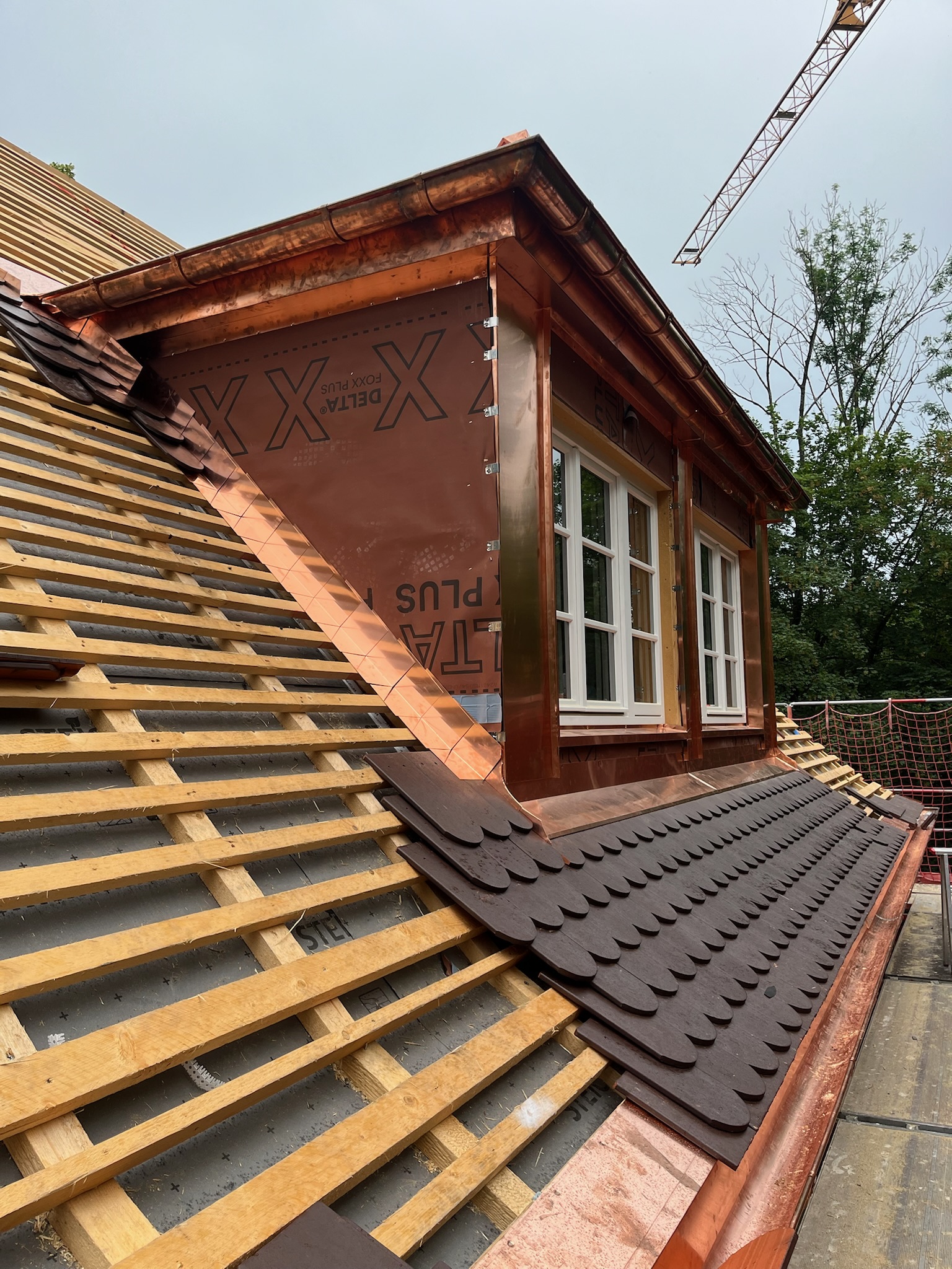 Eingedeckte Dachgaube mit Kupfereinfassung und weißen Holzfenstern