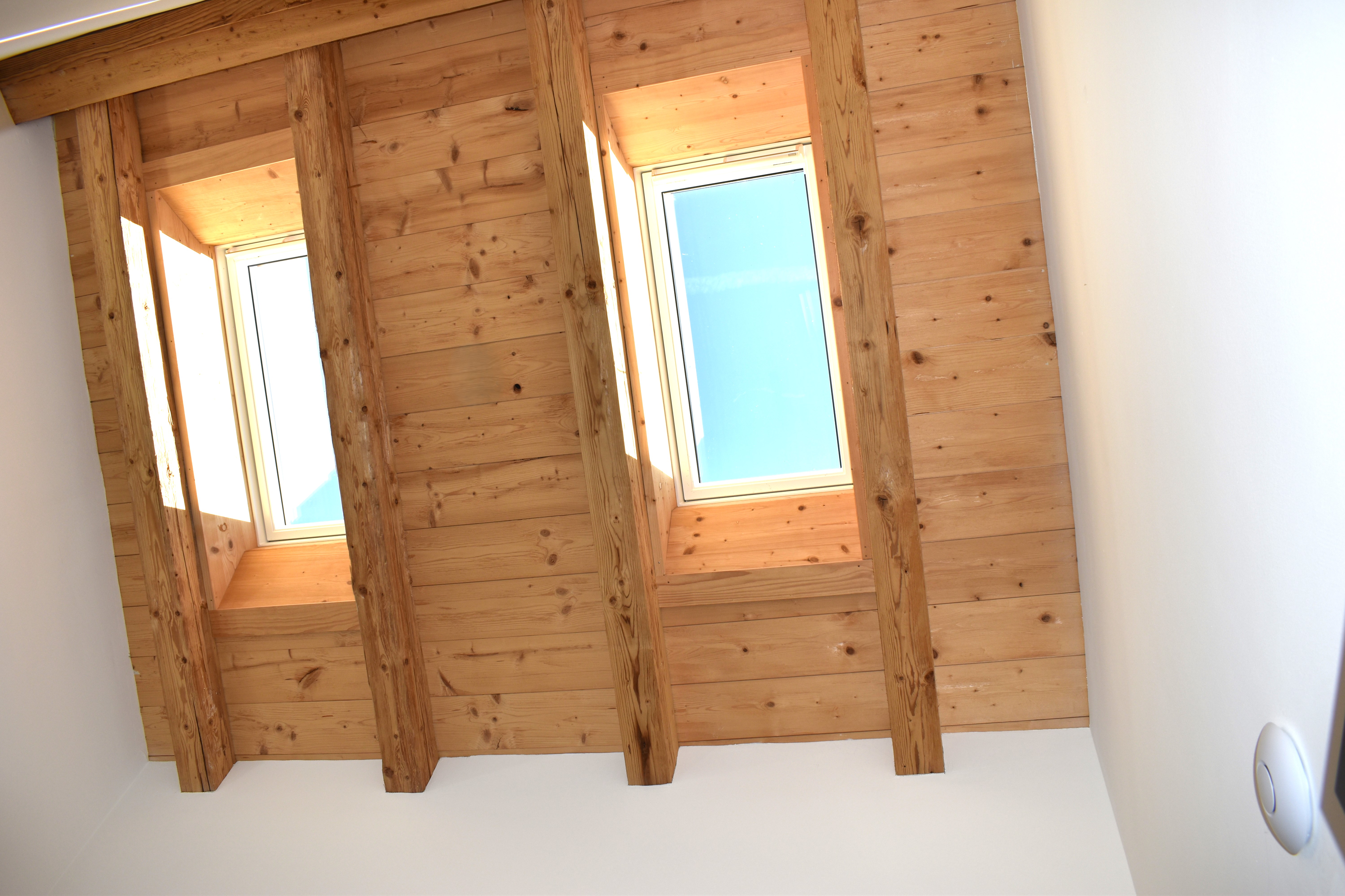 Zwei Dachflächenfenster in einem ausgebauten Dachgeschoss mit sichtbarer Holzkonstruktion