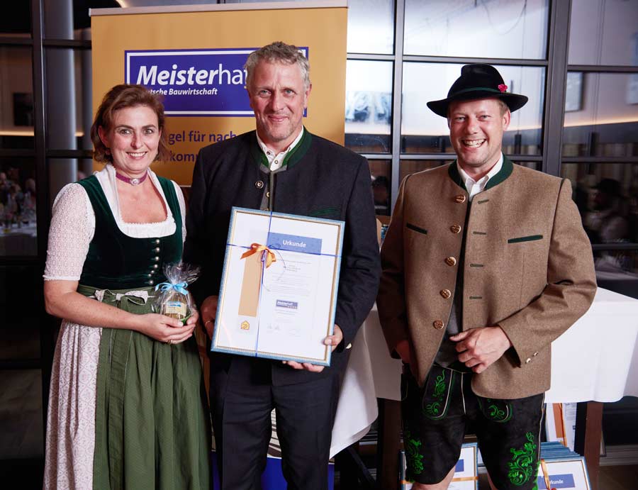 Obermeister Christoph Bammer überreicht die Meisterhaft-Urkunde Hans und Josephine Rieger.