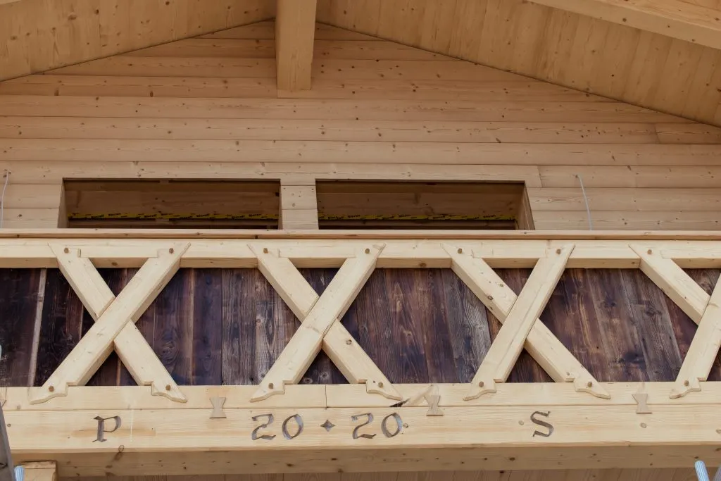 Detailaufnahme des sanierten Holzbalkons eines alten landwirtschaftlichen Betriebs